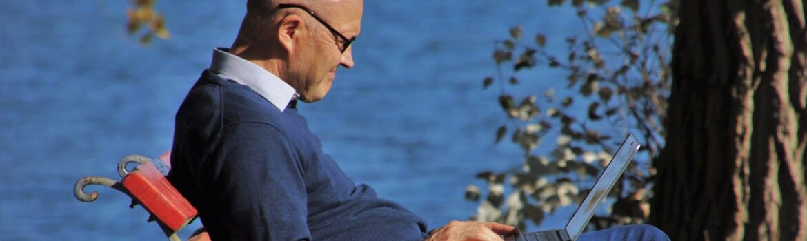 Elderly Man sitting on a bench beside the sea