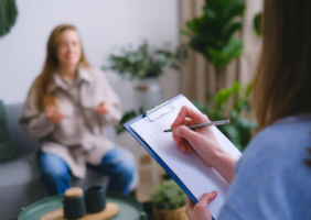 Occupational Therapist taking notes talking with their client