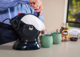 Elderly man using the Uccello Kettle to make tea with the one touch jar opener