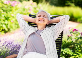 Elderly Woman sitting in the garden, enjoying the summer