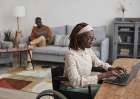 Wheelchair user in adapted living room at home