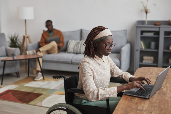 Wheelchair user in adapted living room at home