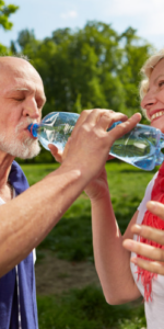 Elderly couple drinking water in the summer sun