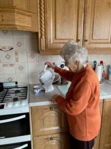 Elderly woman making tea with her Uccello Kettle in the kitchen