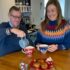 Elderly Father and Daughter sharing a cup of tea together in festive Christmas clothes