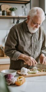 Elderly man living with arthritis cooking in the kitchen